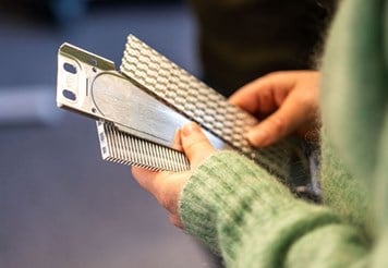 Person holding aluminium components.