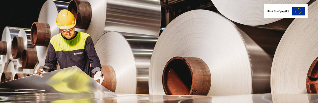 Employee examining flat rolled aluminium.