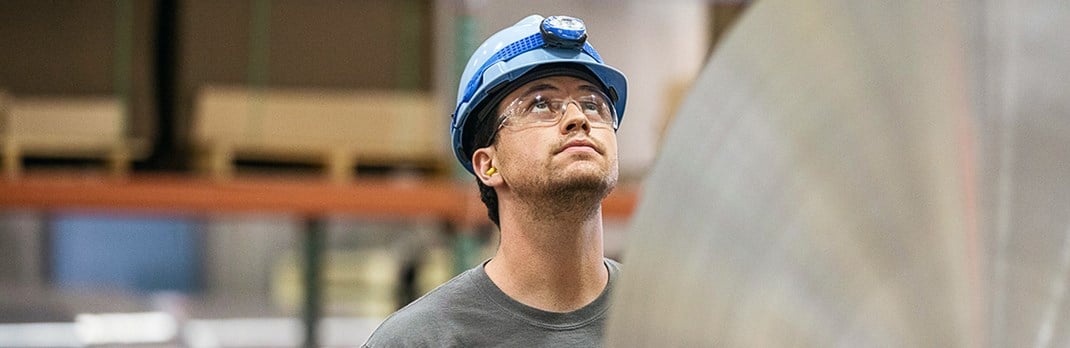 Employee looking up at aluminium coil.