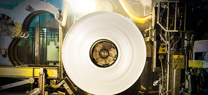 Machinery rolling aluminium into a coil.