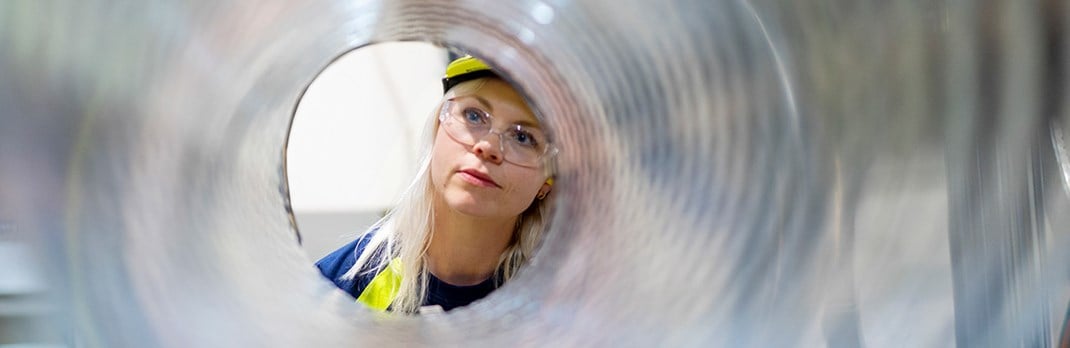 Employee looking through the center of an aluminium coil.