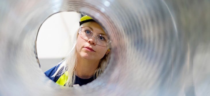 Employee looking through the center of an aluminium coil.
