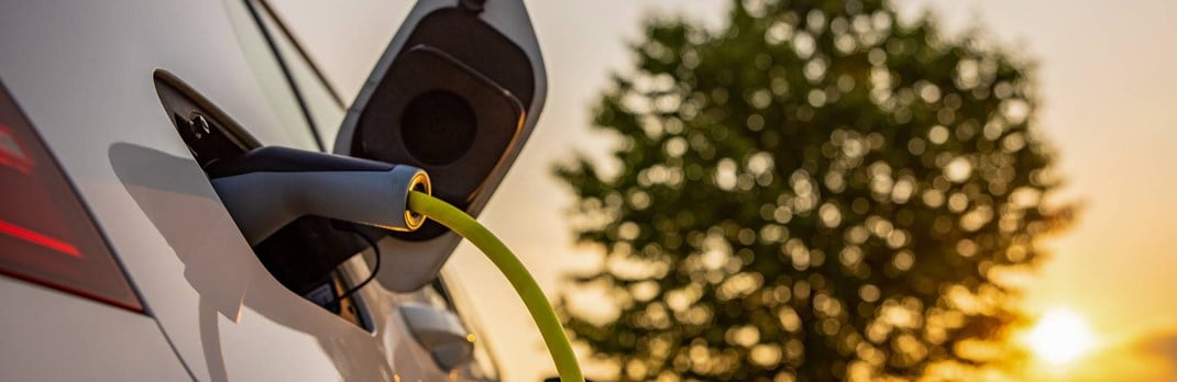 Close up of electric car plugged into charger.