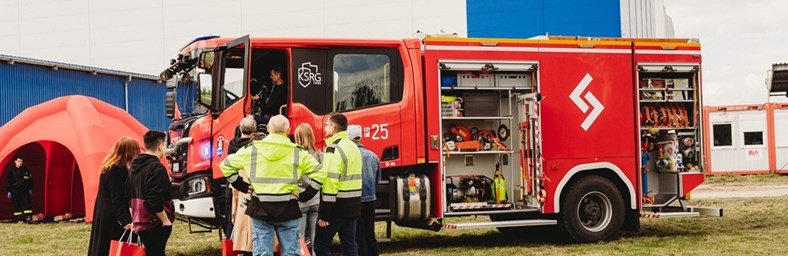 Employees next to a firetruck learning fire safety.